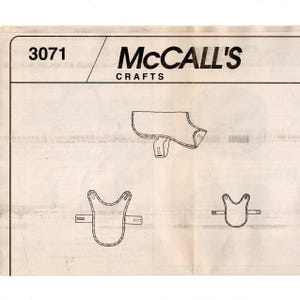 May include: A vintage McCall's Crafts sewing pattern, number 3071, featuring line drawings of a dog coat and saddle. The pattern includes various sizes and design elements, printed on aged paper.