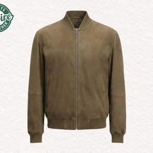 Puede incluir: Chaqueta bomber de ante verde oliva con cierre de cremallera completa. La chaqueta tiene cuello, puños y dobladillo de canalé. El logotipo "Jackets Empire Leather" está en la esquina superior izquierda. Una prenda de abrigo clásica.
