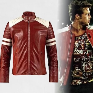 May include: A burgundy leather jacket with white accents on the shoulders and sleeves. The jacket has a full-length zipper and a stand-up collar. The sleeves have white stripes. The jacket is a classic style.
