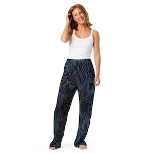 May include: A person wearing a white vest top and patterned pajama trousers. The pajama trousers feature a dark background with a colourful, abstract design in shades of blue, green, and purple.