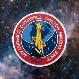 May include: A circular mission patch featuring a red border with the text CLIFFORD GUTIERREZ CHILTON GODWIN JONES APT SRL-1. The center displays a blue globe, a yellow star with trailing light, a yellow orbital ring, and a black space shuttle silhouette.