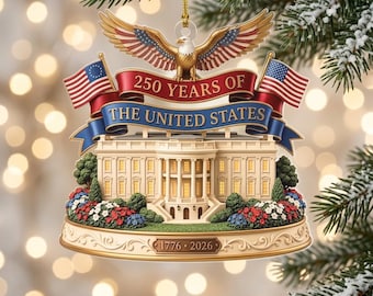 May include: A commemorative holiday ornament featuring a detailed White House model, a bald eagle with spread wings, and two American flags. A red and blue banner displays the text 250 YEARS OF THE UNITED STATES, with 1776-2026 on the base.