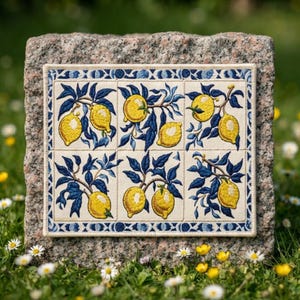 May include: A rectangular fabric panel featuring an embroidered grid of six squares, each displaying yellow lemons with dark blue leaves and stems. The design is framed by a decorative blue and white border on a cream-colored background.