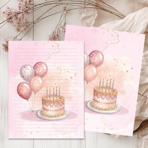 May include: Two pink stationery sheets with a watercolour design. One sheet features a birthday cake with candles and balloons. The other sheet has a similar cake and balloons design. Both sheets have a pink background with gold accents.