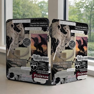 May include: Two phone cases with a fantasy theme. Each case features a collage of dragon illustrations, text, and lightning bolts. The text includes phrases like "I control the shadows" and "Violence". The cases have a black quilted background.