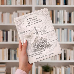 May include: A light-coloured tablet case with a detailed illustration of a sword, flowers, and a dove. The case has inspirational text, including "To the stars who listen" and "I will not be afraid."