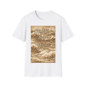 Könnte beinhalten: Eine weiße Keramiktasse mit schwarzem Henkel und dem Text "But First, Coffee" in fetter, schwarzer Schrift. Die Tasse steht vor einem verschwommenen Hintergrund, der eine gemütliche Umgebung suggeriert.