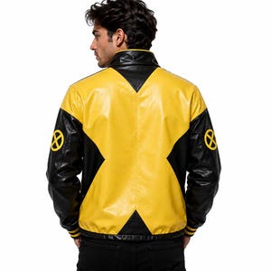 Puede incluir: Una chaqueta de cuero negra y amarilla con un gran dise&ntilde;o en forma de X amarilla en la espalda y parches circulares amarillos con el logo de una X en ambas mangas. La chaqueta tiene cuello alto, mangas largas con pu&ntilde;os acanalados.