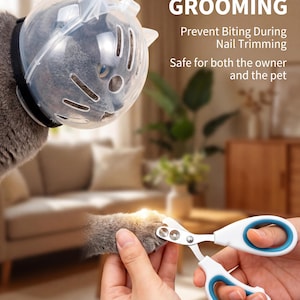 May include: A cat wearing a clear plastic muzzle with a black strap, and a person holding white and blue nail clippers. The image includes the text "STRESS-FREE GROOMING".