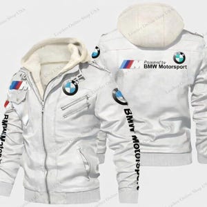 Puede incluir: Chaqueta de cuero blanca con capucha y logotipos de BMW Motorsport. La chaqueta tiene cremallera, múltiples bolsillos y el texto "BMW Motorsport" impreso en la manga.