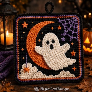 Puede incluir: Un agarrador de cocina cuadrado de ganchillo con fondo negro, un fantasma blanco, una luna creciente naranja y nubes blancas. El diseño incluye pequeñas estrellas naranjas, una telaraña morada y una pequeña araña naranja. Texto ElegantCraftBoutique.