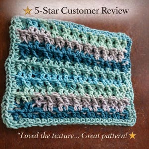 A single rectangular crochet dishcloth with a textured pattern in variegated shades of blue, teal, and gray on a wooden surface, accompanied by a 5-star customer review text.