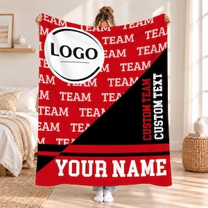 Könnte beinhalten: Eine rechteckige Fleecedecke mit rotem Hintergrund und dem wiederholten weißen Text "TEAM". Ein großer weißer Kreis enthält den schwarzen Text "LOGO". Ein schwarzer diagonaler Bereich zeigt den vertikalen Text "CUSTOM TEAM CUSTOM TEXT" und "YOUR NAME".