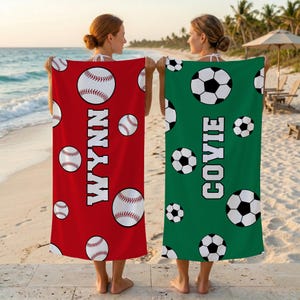May include: Two rectangular beach towels. The left towel is red with white baseball graphics and the name WYNN in white block letters. The right towel is green with black and white football graphics and the name COVIE in white block letters.