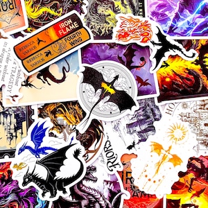 May include: A collection of fantasy-themed stickers featuring dragons in various colors and styles. Some stickers include text such as "IRON FLAME FOURTH WING" and "REBECCA YARROS". The stickers have a white border and are arranged on a surface.