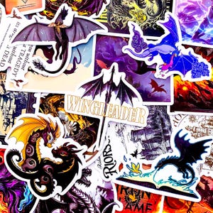 May include: A collection of fantasy-themed stickers featuring various dragon designs in shades of purple, blue, gold, and black. Some stickers include the text "WINGLEADER" and other phrases. The stickers are of different sizes and shapes.