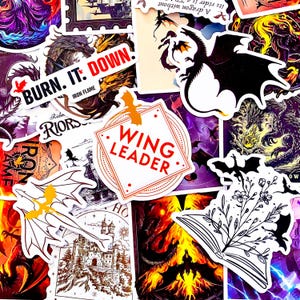 May include: A collection of fantasy-themed stickers featuring dragons, castles, and flames. Some stickers have text like "BURN IT: DOWN" and "WING LEADER". The stickers are in various colors, including purple, orange, and black, and are suitable for decorating laptops, water bottles, or notebooks.