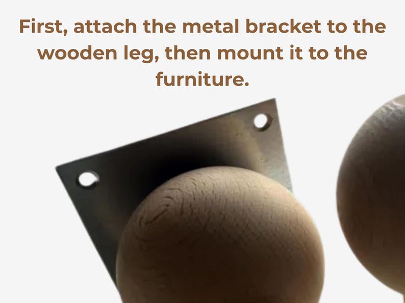 Op de afbeelding: Een lichtgekleurde houten bol bevestigd aan een vierkante metalen montagebeugel met twee zichtbare schroefgaten. De tekst erboven luidt: First, attach the metal bracket to the wooden leg, then mount it to the furniture. Een tweede houten bol is zichtbaar.