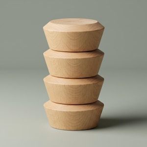 May include: A vertical stack of four light-coloured wooden bowls with a smooth, natural grain finish. Each bowl features a wide, flat top surface and tapered sides that angle inward towards the base, creating a uniform, cylindrical appearance.