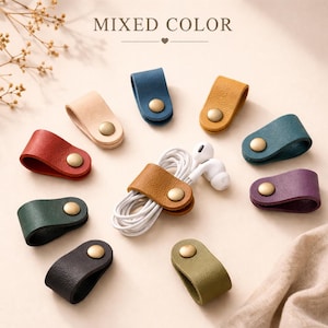 May include: A collection of colorful leather cable organizers with brass snap closures. The organizers are in various colors, including red, blue, green, and tan. The text "MIXED COLOR" is at the top of the image.