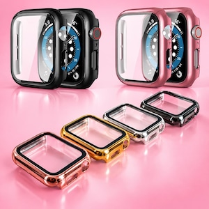 Könnte beinhalten: Zwei Smartwatches mit Schutzhüllen in Schwarz und Roségold, die digitale Zifferblätter mit kreisförmigen Anzeigen aufweisen. Darunter sind vier leere Schutzhüllen in einer Reihe angeordnet, mit metallischen Oberflächen in Roségold, Gold, Silber und Schwarz.