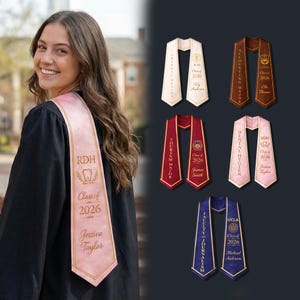 May include: A graduation sash with the text "RDH Class of 2026 Jessica Taylor" in pink, worn by a person in a black graduation gown. Additional sashes in various colors and majors, including Graphic Design, Tourism, and Accounting, are also displayed.
