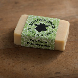 May include: A bar of goat milk soap with a green and white label that reads "Gretta's Goats Goat Milk Soap" and "Tea Tree Eucalyptus".