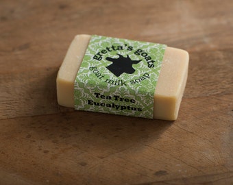 May include: A bar of goat milk soap with a green and white label that reads "Gretta's Goats Goat Milk Soap" and "Tea Tree Eucalyptus".