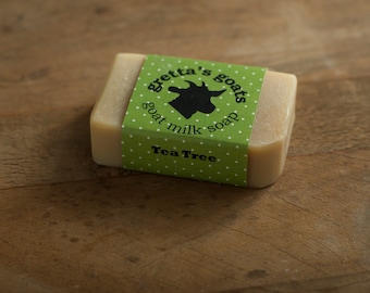 May include: A bar of goat milk soap with a green label that says "Gretta's Goats Goat Milk Soap Tea Tree". The label has a white silhouette of a goat on it.