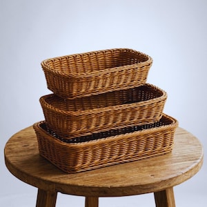 May include: A set of three ceramic mugs with a speckled, matte finish. The mugs are in shades of cream, light gray, and dark gray. Each mug has a simple, minimalist design and a rounded handle.