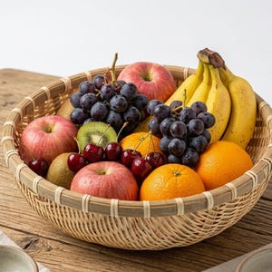 May include: A woven wicker basket overflowing with fresh fruit. The basket contains red apples, ripe bananas, dark purple grapes, oranges, kiwi, and cherries. The basket is set on a wooden surface.
