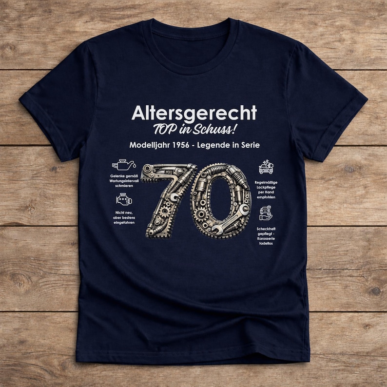 May include: Navy blue t-shirt with the text "Altersgerecht TOP in Schuss! Modelljahr 1956 - Legende in Serie". The number 70 is designed with gears and tools. Additional text and icons are also present.