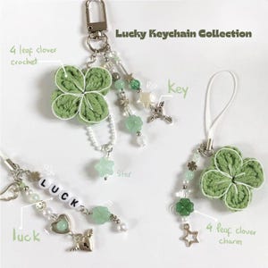 May include: A collection of lucky keychains featuring green crochet four-leaf clovers, star charms, and beaded accents. One keychain includes the word "LUCK" spelled out in white beads. The keychains are part of the "Lucky Keychain Collection".