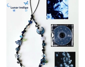 May include: A beaded phone charm with a black cord, featuring blue, clear, and iridescent beads in various shapes, including flowers, butterflies, and a crescent moon. The text "Lunar Indigo" is displayed with a moon and butterfly graphic.