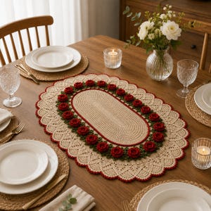 May include: An oval crochet table runner featuring a beige center, a border of dark green leaves, and a ring of small red roses. The runner has a wide, scalloped beige lace edge trimmed with red thread, creating a decorative floral centerpiece.