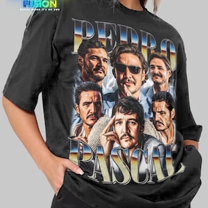 以下が含まれることがあります： ペドロ・パスカルの画像をコラージュした黒いTシャツで、レトロなフォントで「PEDRO PASCAL」と書かれています。シャツの左上には「FASHION FUSION」のロゴがあります。