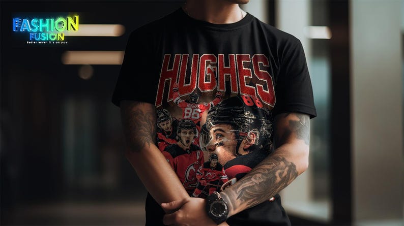 K&ouml;nnte beinhalten: Schwarzes T-Shirt mit dem Namen "HUGHES" in roten Blockbuchstaben. Das Shirt zeigt eine Grafik eines Eishockeyspielers in einem schwarzen Helm und einem roten Trikot. Das Logo "Fashion Fusion" befindet sich oben links.