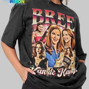 Könnte beinhalten: Schwarzes Unisex-T-Shirt mit einer Grafik der Figur Bree Van de Kamp aus der Fernsehserie. Das Design enthält den Namen "Bree" und mehrere Bilder der Figur. Das Shirt hat auch das Fashion Fusion Logo.