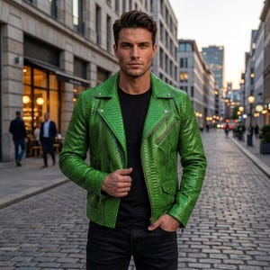Puede incluir: Una chaqueta de moto de color verde vibrante con un patrón texturizado de piel de serpiente, solapa ancha con muescas, cremalleras metálicas plateadas en la parte delantera y las mangas, y un pequeño bolsillo con solapa en el lado inferior izquierdo.