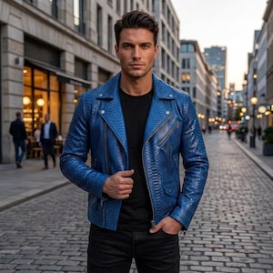 May include: A vibrant blue motorcycle jacket featuring a textured snakeskin-like pattern, a wide notched lapel, silver-toned metal zippers on the chest and pockets, and a snap button closure, worn over a plain black t-shirt and black pants.
