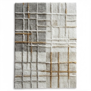 Puede incluir: Una alfombra rectangular con un patrón de cuadrícula geométrica. La alfombra presenta una mezcla de cuadrados y rectángulos grises, blancos y beige. El diseño tiene una apariencia texturizada, con líneas en relieve que crean la cuadrícula. La paleta de colores es neutra.