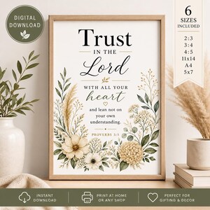 Op de afbeelding: Een ingelijste print met de tekst "Trust in the Lord" in sierlijk schrift, omringd door bloemen aquarel illustraties in crème, beige en groen. De print bevat de tekst "With all your heart" en "Proverbs 3:5".