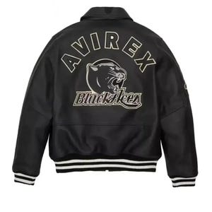 K&ouml;nnte beinhalten: Schwarze Lederjacke mit dem Wort "AVIREX" in wei&szlig;en Buchstaben &uuml;ber den Schultern. Darunter eine Panther-Grafik und die Worte "Black Aces". Die Jacke hat einen Kragen, gerippte B&uuml;ndchen und einen gestreiften Saum.