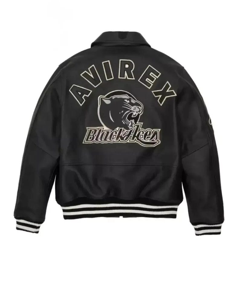 K&ouml;nnte beinhalten: Schwarze Lederjacke mit dem Wort "AVIREX" in wei&szlig;en Buchstaben &uuml;ber den Schultern. Darunter eine Panther-Grafik und die Worte "Black Aces". Die Jacke hat einen Kragen, gerippte B&uuml;ndchen und einen gestreiften Saum.