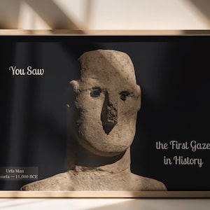 May include: Framed print featuring a stone sculpture of a human head and torso against a black background. Text reads "You Saw" and "the First Gaze in History." The sculpture is identified as Urfa Man, Sanliurfa - 11,000 BCE.