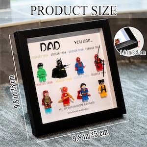 May include: Black framed artwork with the text "DAD" and "YOU ARE..." featuring superhero figures. The frame measures 9.8 inches by 9.8 inches (25 cm x 25 cm) and is 1.6 inches (3.2 cm) deep. The artwork includes the text "YOU ARE OUR FAVOURITE SUPERHERO".
