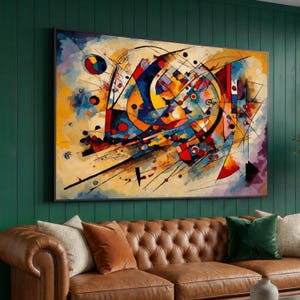 Pode incluir: Impressão de arte abstrata com uma composição dinâmica de formas geométricas e linhas em cores vibrantes, incluindo azul, amarelo, vermelho e laranja. A obra de arte emoldurada está acima de um sofá de couro castanho.