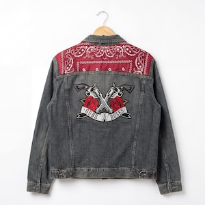 May include: A gray denim jacket with a red paisley bandana panel on the upper back. The jacket features a Guns N' Roses patch with crossed revolvers, red roses, and the band's name on a banner.