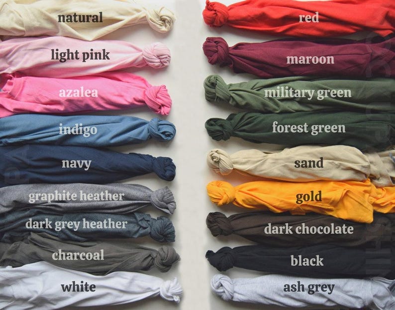 May include: Folded t-shirts in a range of colours, such as natural, light pink, azalea, indigo, navy, graphite heather, dark grey heather, charcoal, white, red, maroon, military green, forest green, sand, gold, dark chocolate, black, and ash grey. Each shirt is labelled.