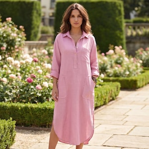 Può includere: Abito in lino rosa chiaro con colletto, maniche lunghe e due tasche frontali. L'abito ha una chiusura con bottoni sul davanti e una vestibilità ampia. L'abito, lungo fino al ginocchio, ha spacchi laterali, ideale per l'estate.